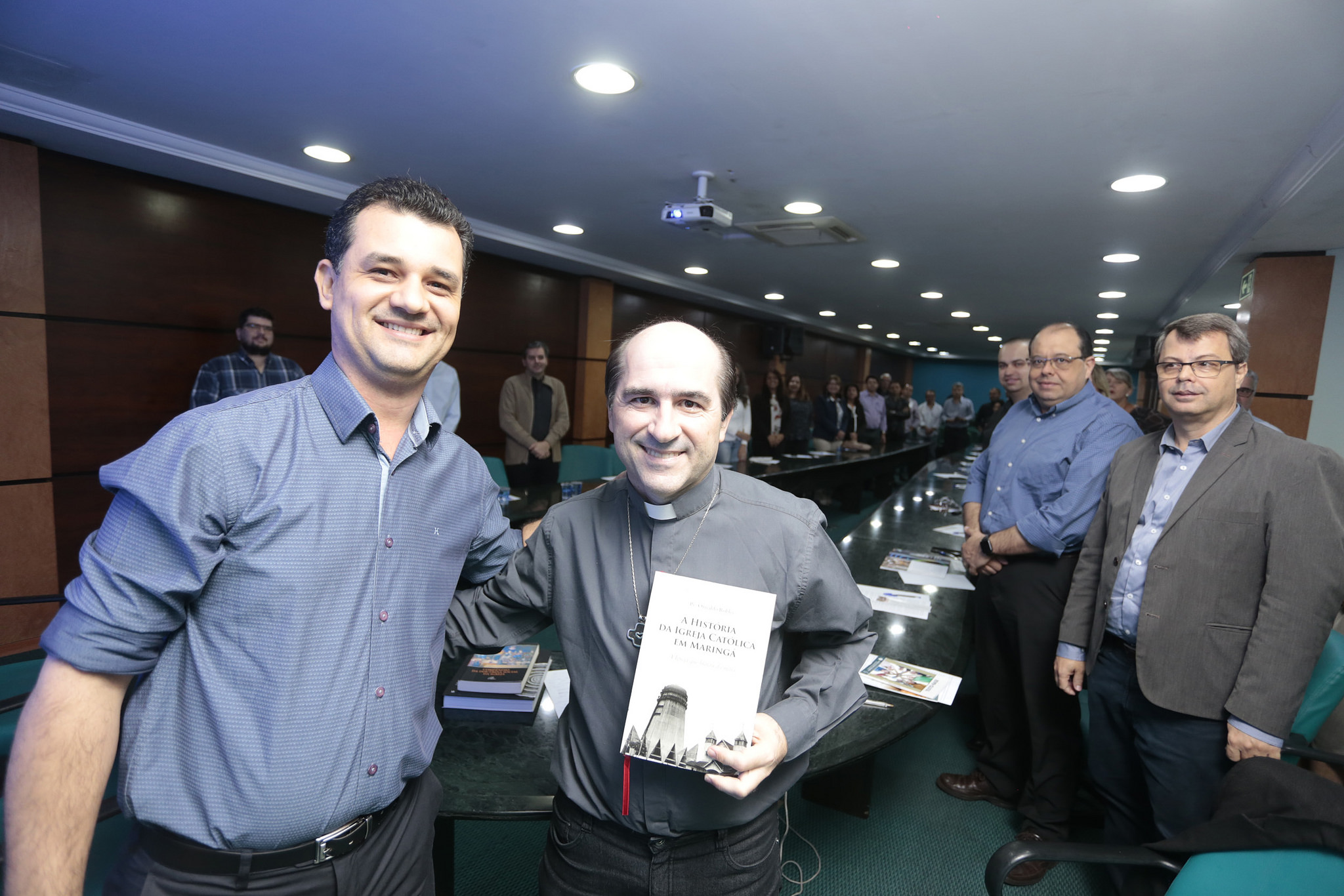 Everton Barbosa entrega o livro dos 60 anos da Arquidiocese de Maringá ao padre Joãozinho